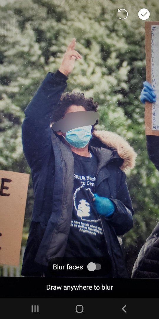 The same photo of a protester as before, but their face has been blurred out of the photo