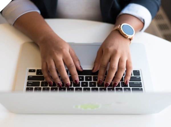 Header image of a woman typing on her computer