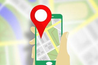 An image of an animated hand holding up a phone with a location pin over a map.